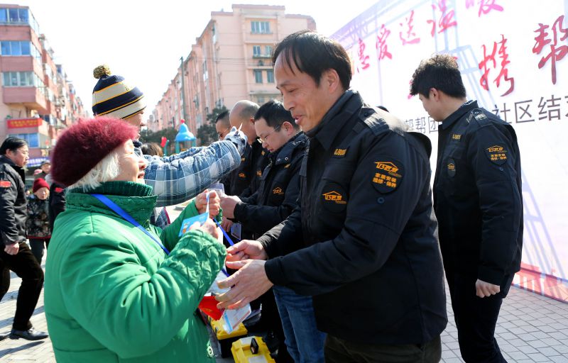 1488761216101559.jpg 图1 结对的老人为师傅佩戴服务卡.jpg